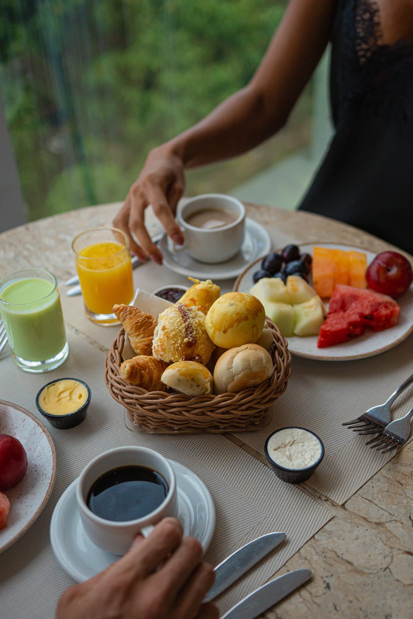 Mesa de café da manhã com frutas, pães e sucos